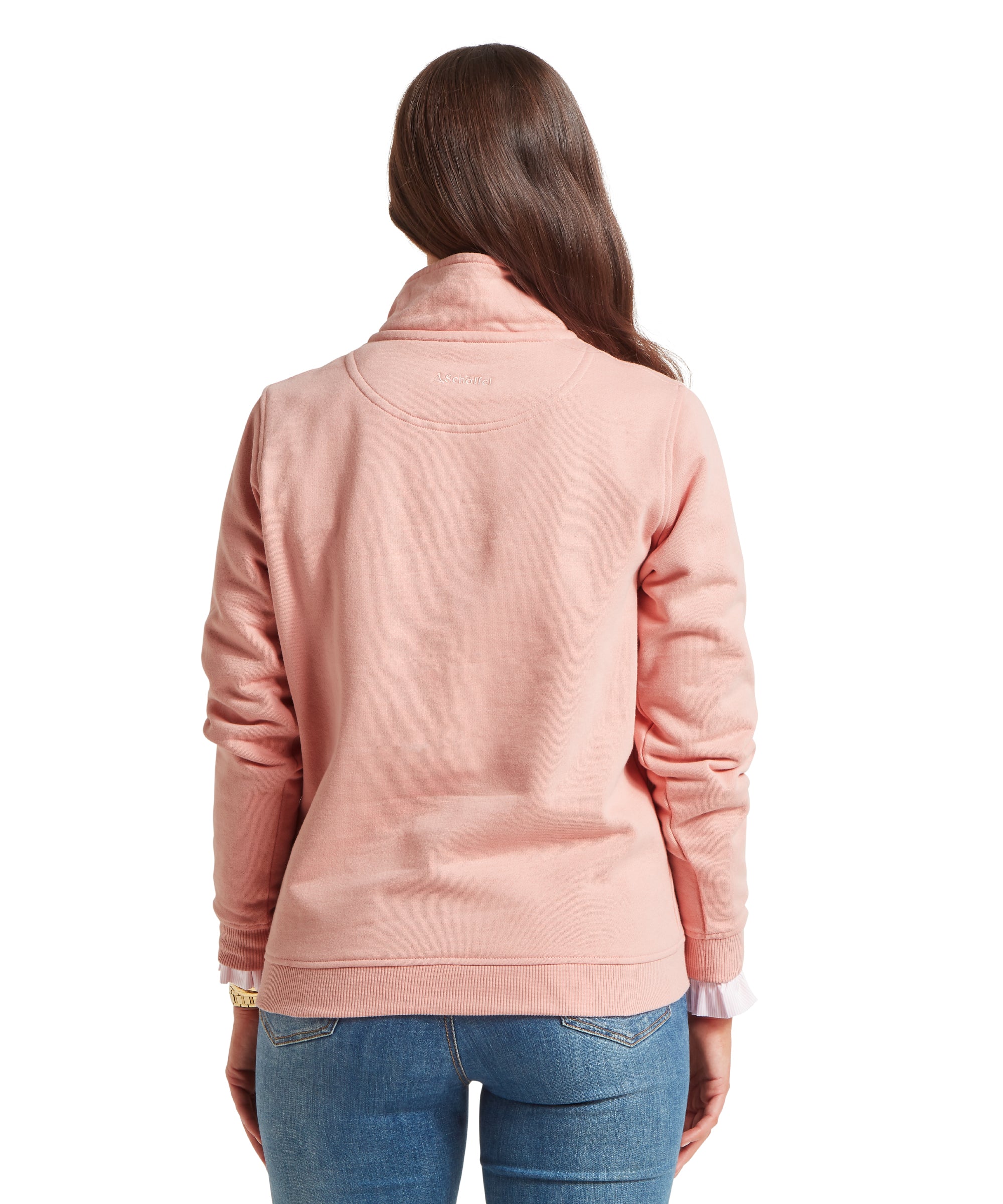 Back view of a woman wearing a light pink sweatshirt with a high collar. Paired with blue jeans. “Schöffel” embroidered below the collar on the upper back. Standing upright against a plain white background.