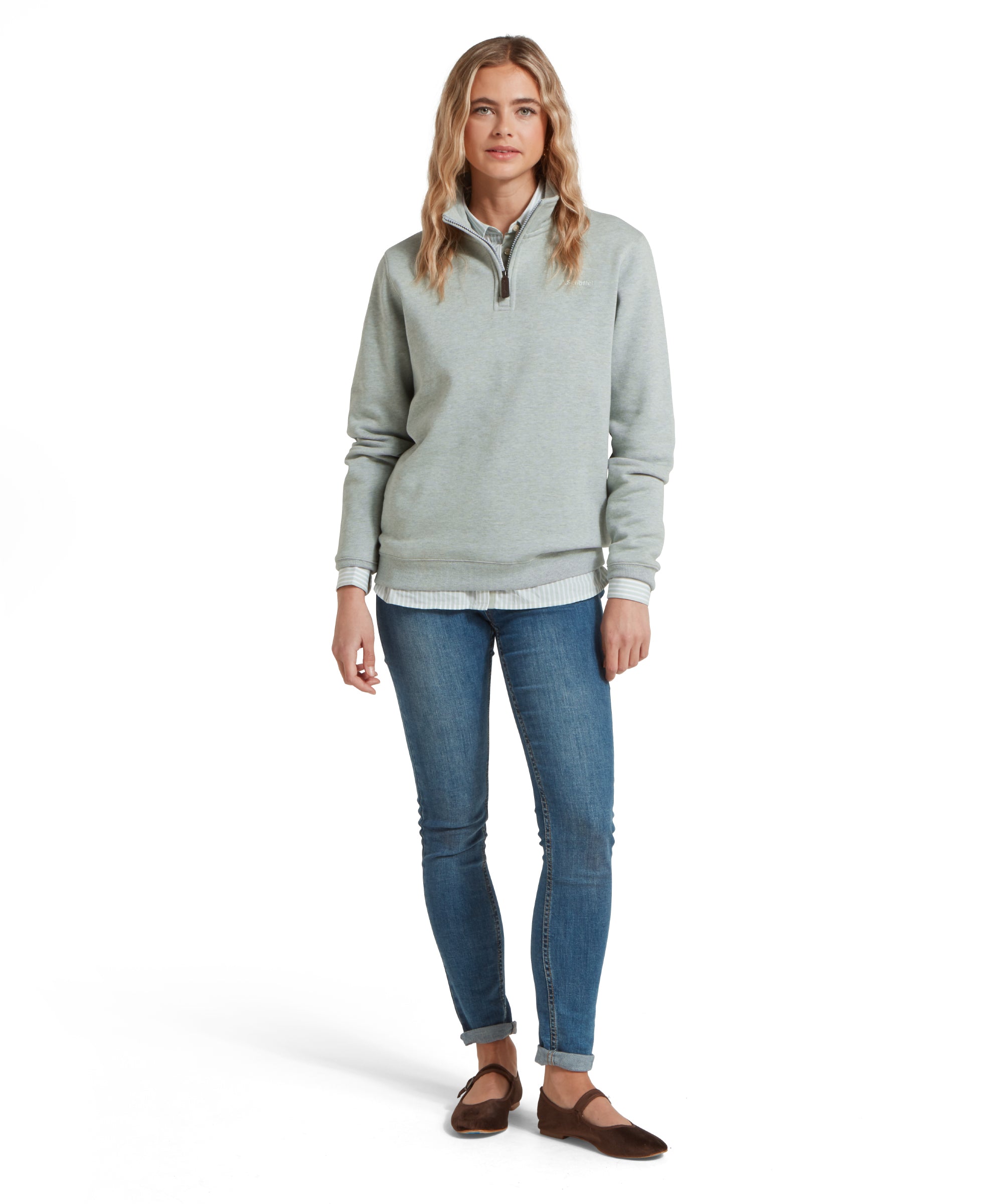 Full-body shot of a woman in a Schöffel Sennen Cove Sweatshirt for Women in Light Blue, blue jeans, and red pumps, posing casually.