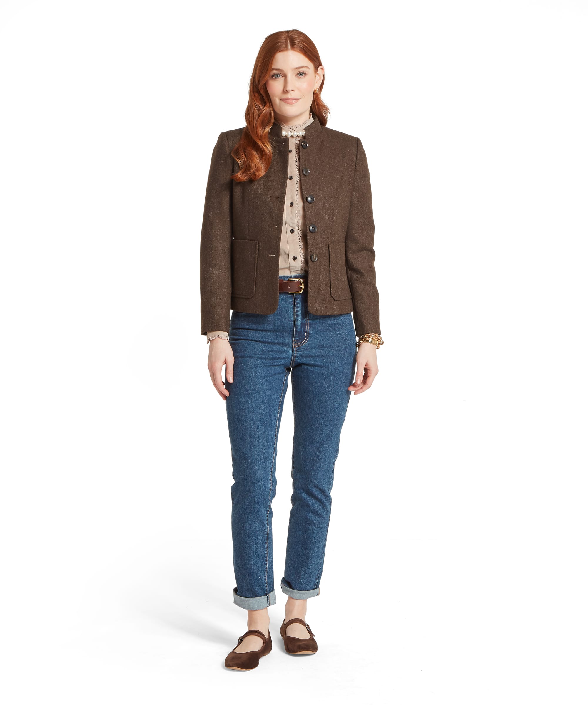 Full-length view of a woman wearing the Schöffel Women's St Abbs Tweed Blazer in Dark Chocolate Herringbone, showing the collarless silhouette, patch pockets and fitted waist, layered open over a stone cord shirt and blue jeans with dark suede Mary Jane flats