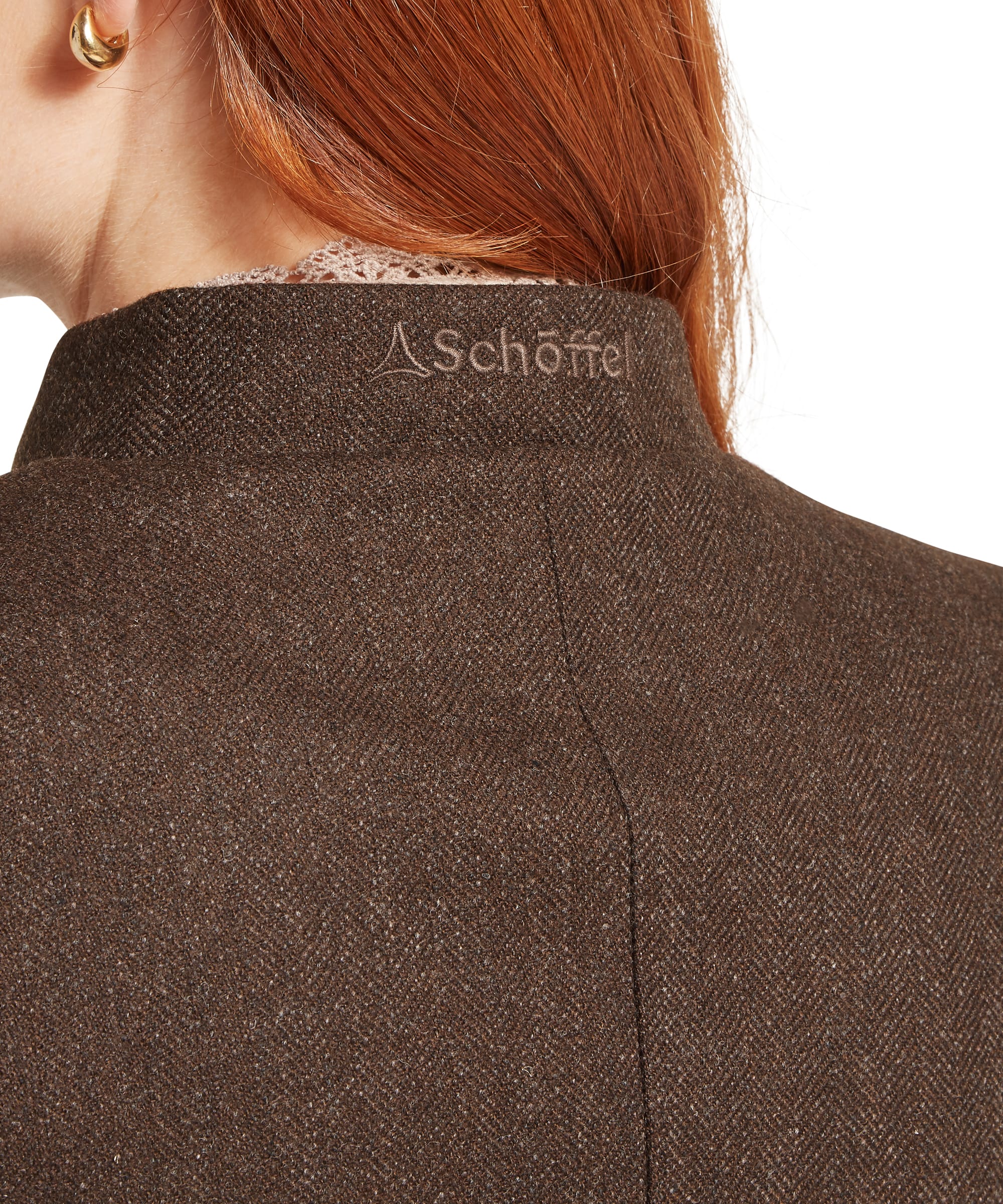 Rear collar close-up of the Schöffel Women's St Abbs Tweed Blazer in dark brown herringbone tweed, showing the stand collar, tonal Schöffel embroidered logo at the back neck, and fine herringbone weave texture with flecked yarn detail