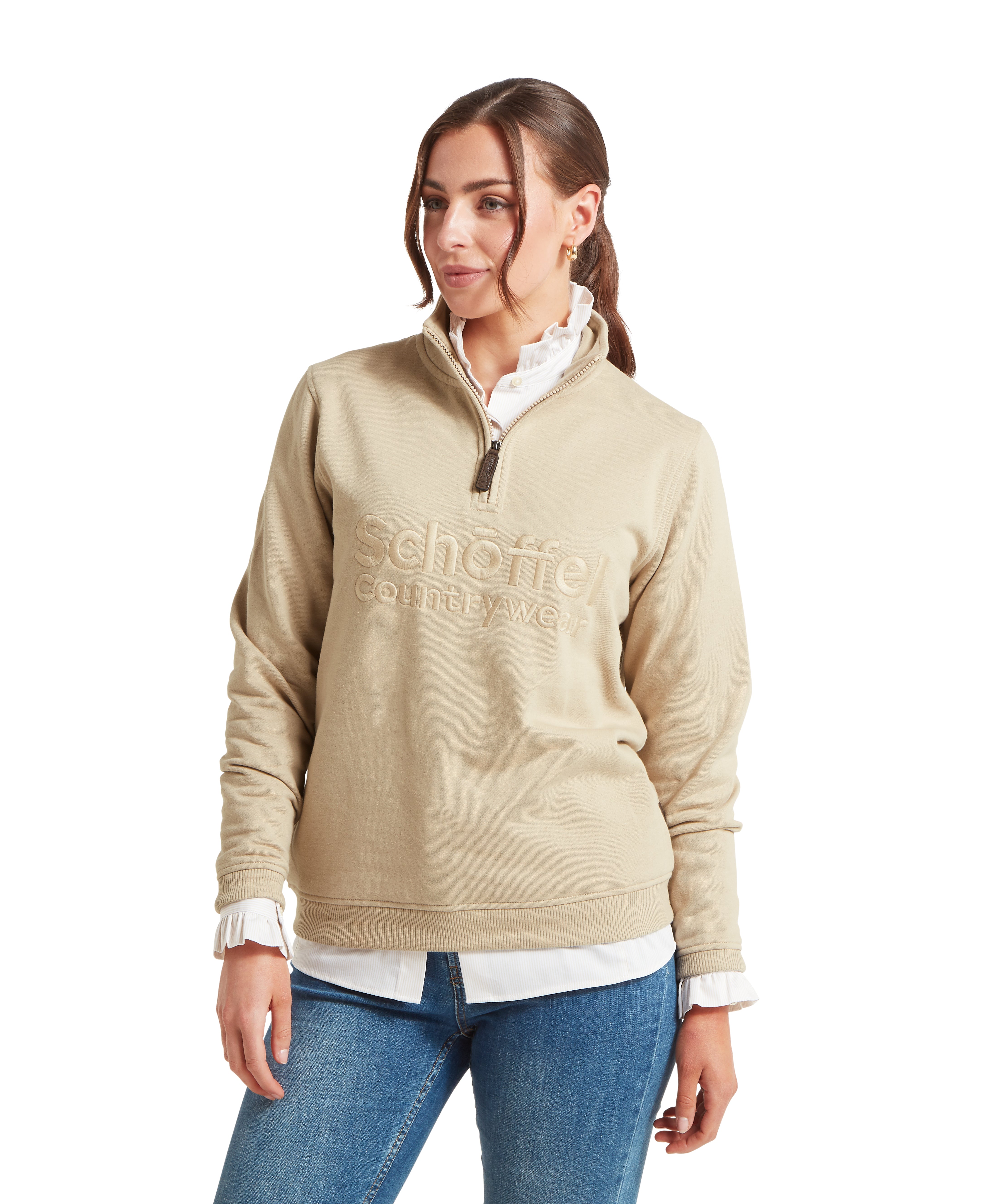 Woman wearing a beige sweatshirt with a Schöffel countrywear logo against a white background
