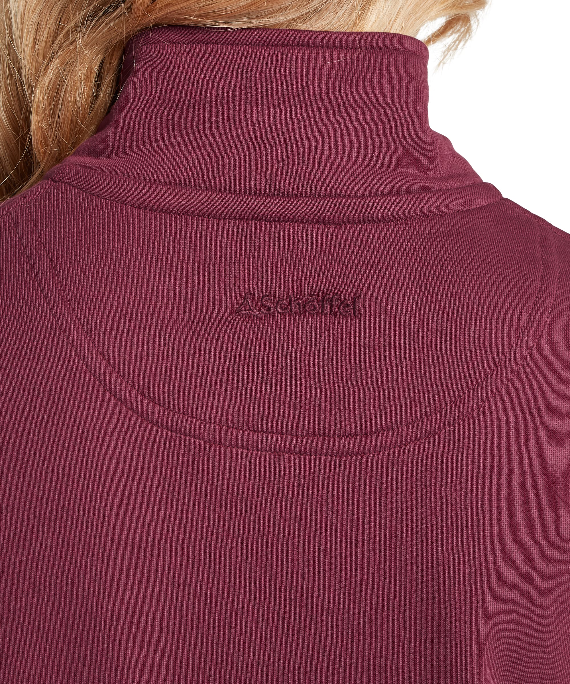 Rear neck close-up of the Schöffel Women's St Issey Sweatshirt in burgundy red, highlighting the ribbed stand collar, curved back yoke topstitching, and tonal Schöffel logo embroidery on the smooth jersey back panel