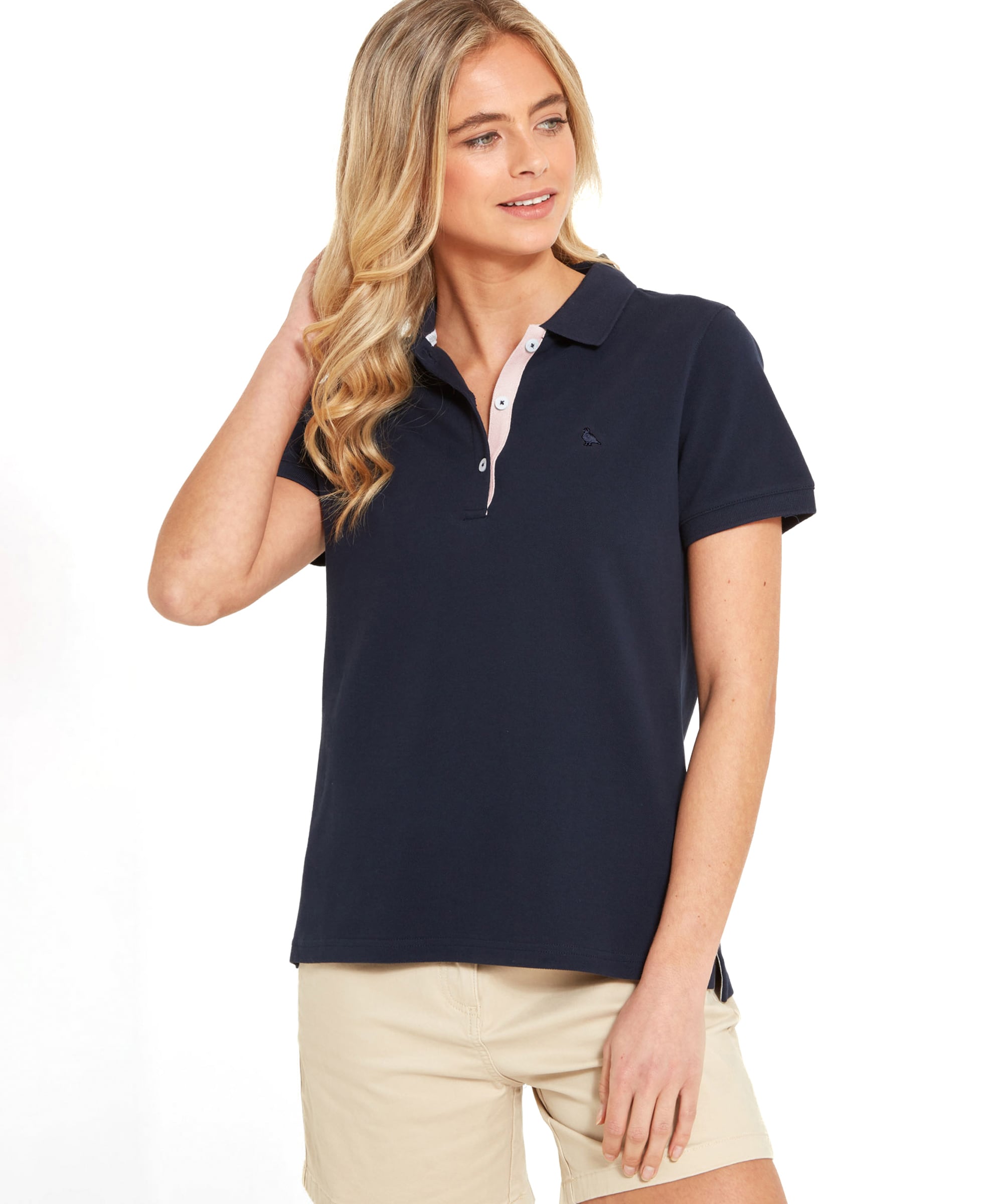 Schöffel Women's St Ives Polo Shirt in navy, close-up on model with contrast pink placket trim, styled with khaki shorts