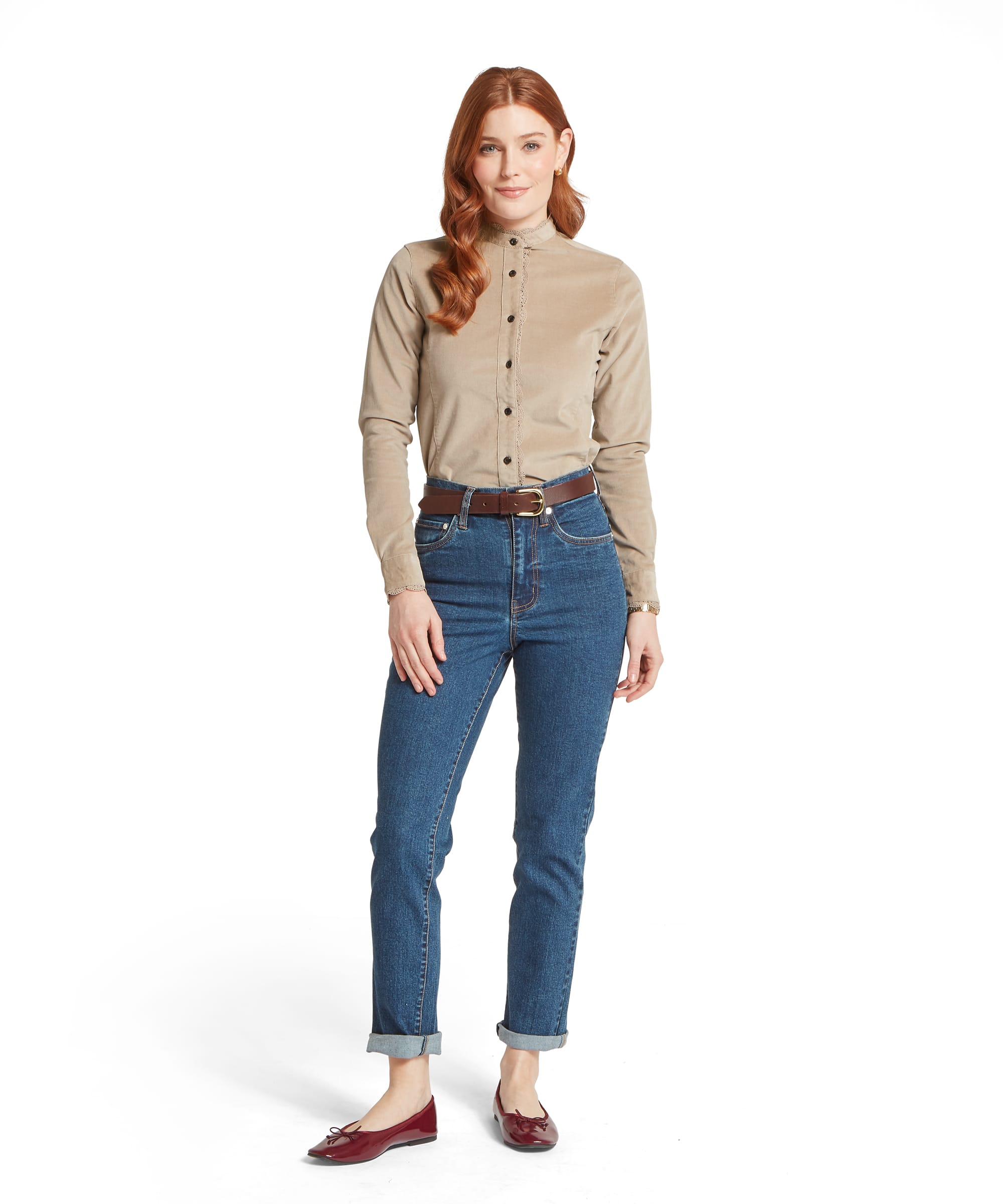 Full-length front view of the Schöffel Women's Thetford Cord Shirt in Stone, showing the fitted silhouette, lace-trim button placket and stand collar, worn with straight-leg blue jeans, a tan leather belt and burgundy ballet flats