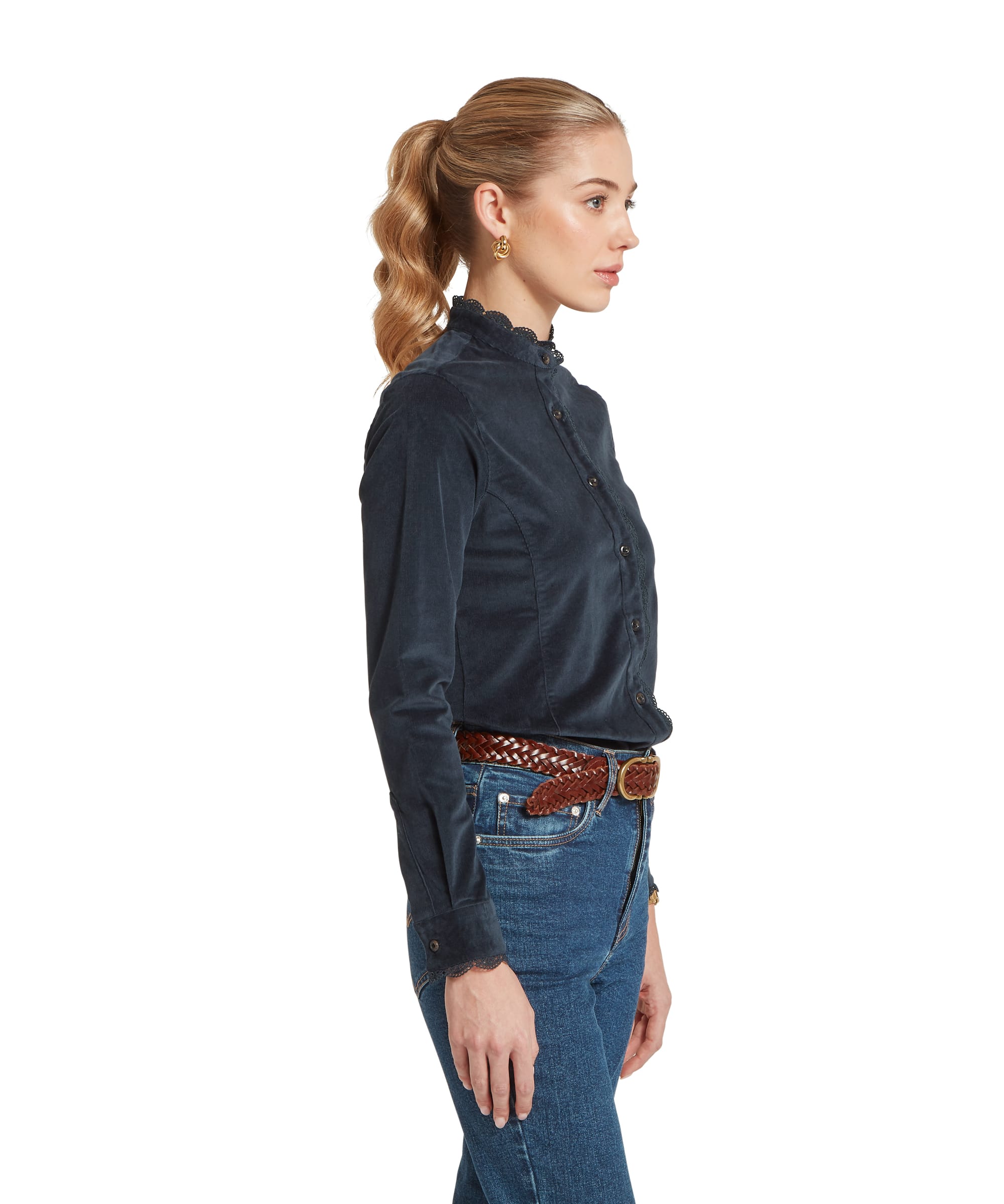 Side view of the Women's Schöffel Thetford Cord Shirt in navy needlecord, showing the tailored fit and lace-edged standing collar, tucked into blue jeans with a woven leather belt.