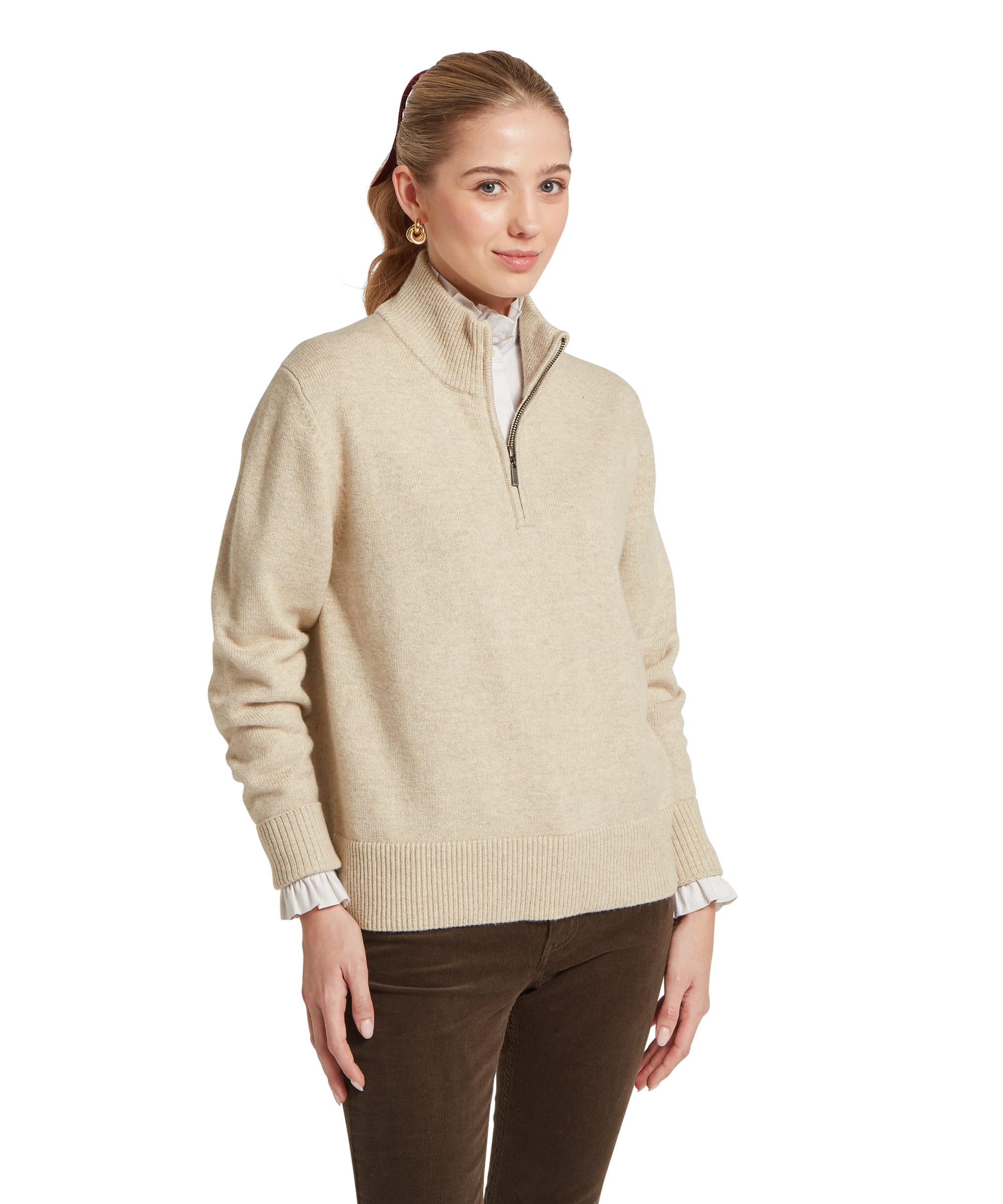 Three-quarter view of the Women's Schöffel Thoralby Quarter-Zip Jumper in oatmeal cream, an oversized lambswool knit with a ribbed stand collar, quarter-zip fastening and deep ribbed hem, layered over a white frill-collar shirt with dark olive cord trousers.