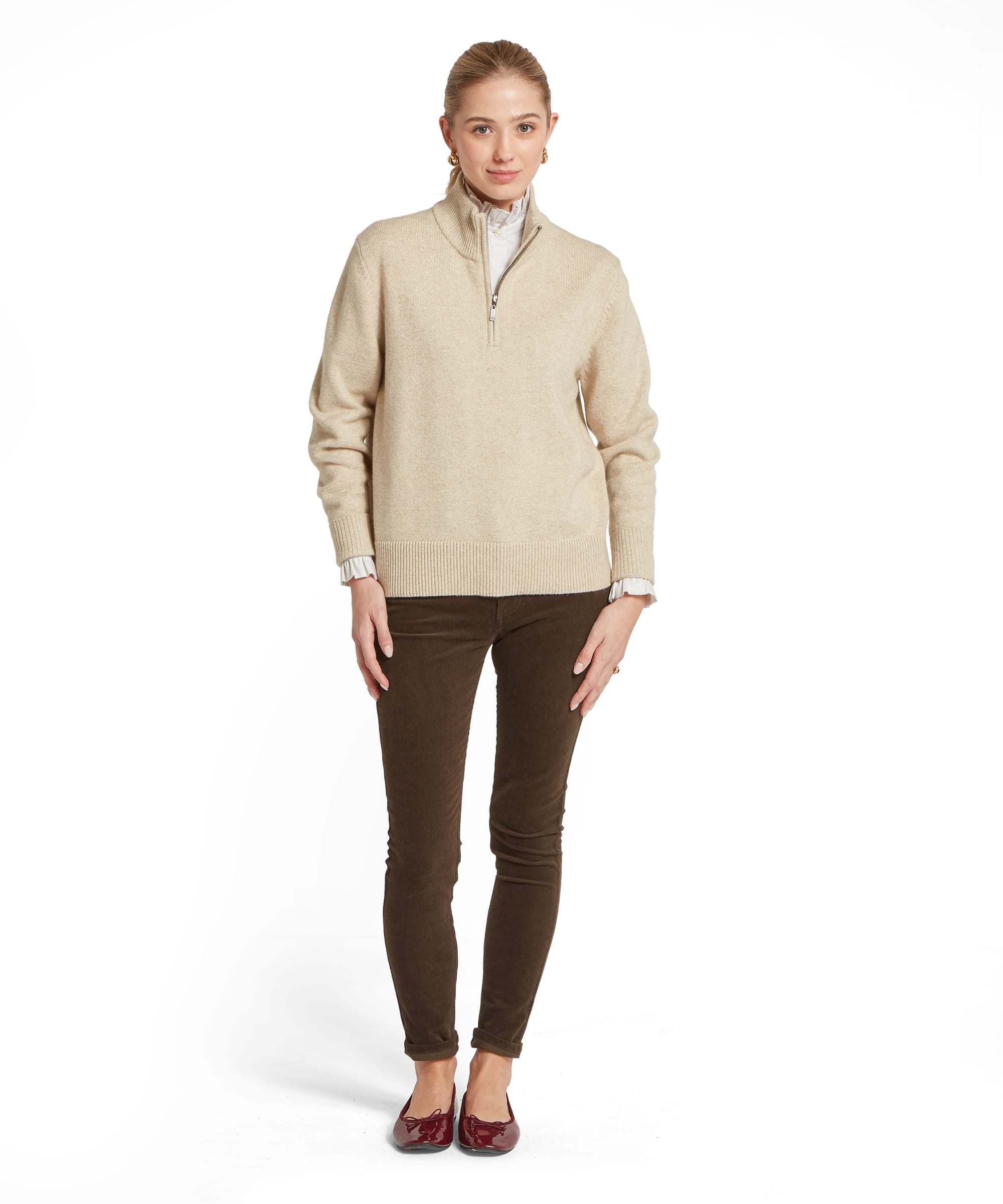 Full-length view of the Women's Schöffel Thoralby Quarter-Zip Jumper in oatmeal cream, showing the relaxed oversized silhouette with ribbed cuffs and hem, layered over a white frill-collar shirt, with slim dark olive cord trousers and burgundy bow ballet flats.