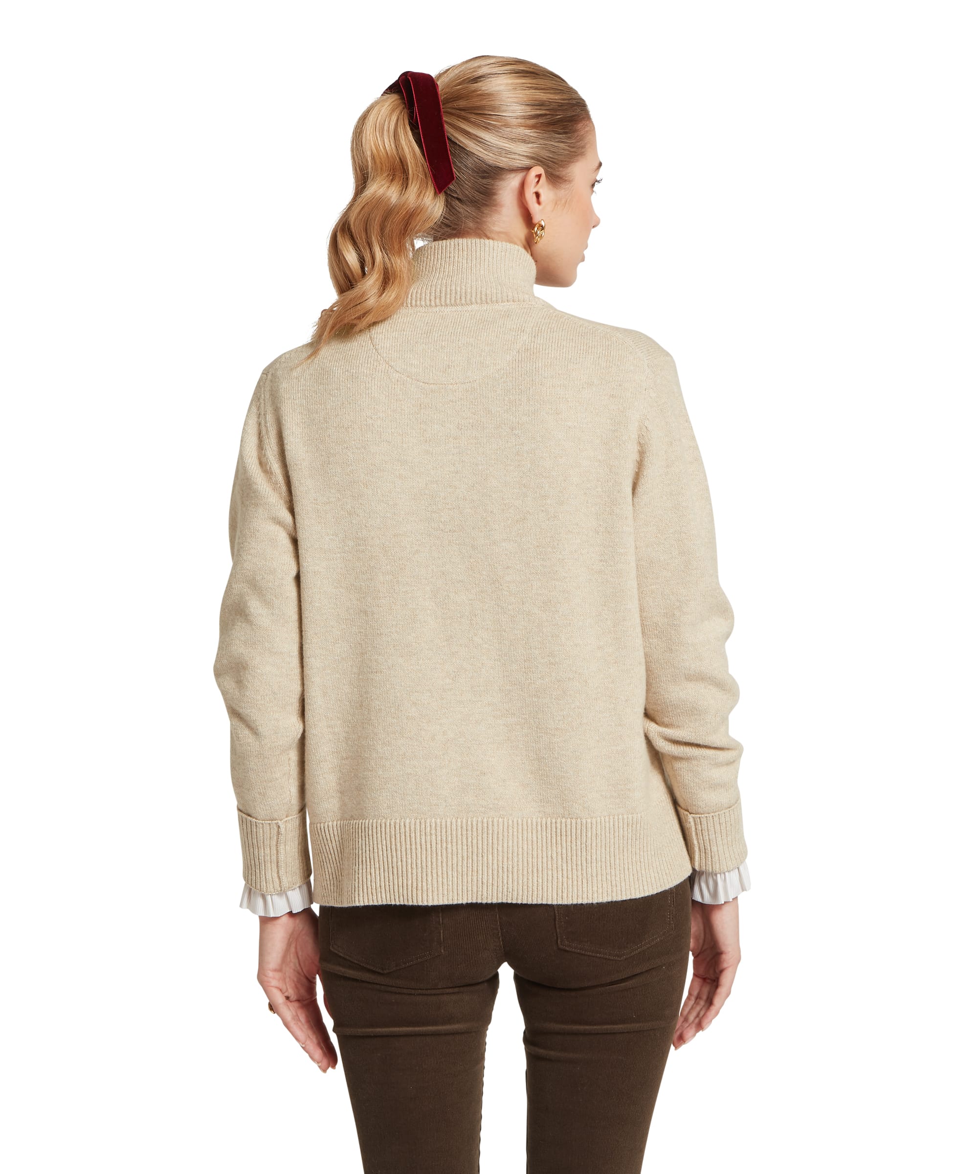 Rear view of a woman wearing a beige jumper on a white background