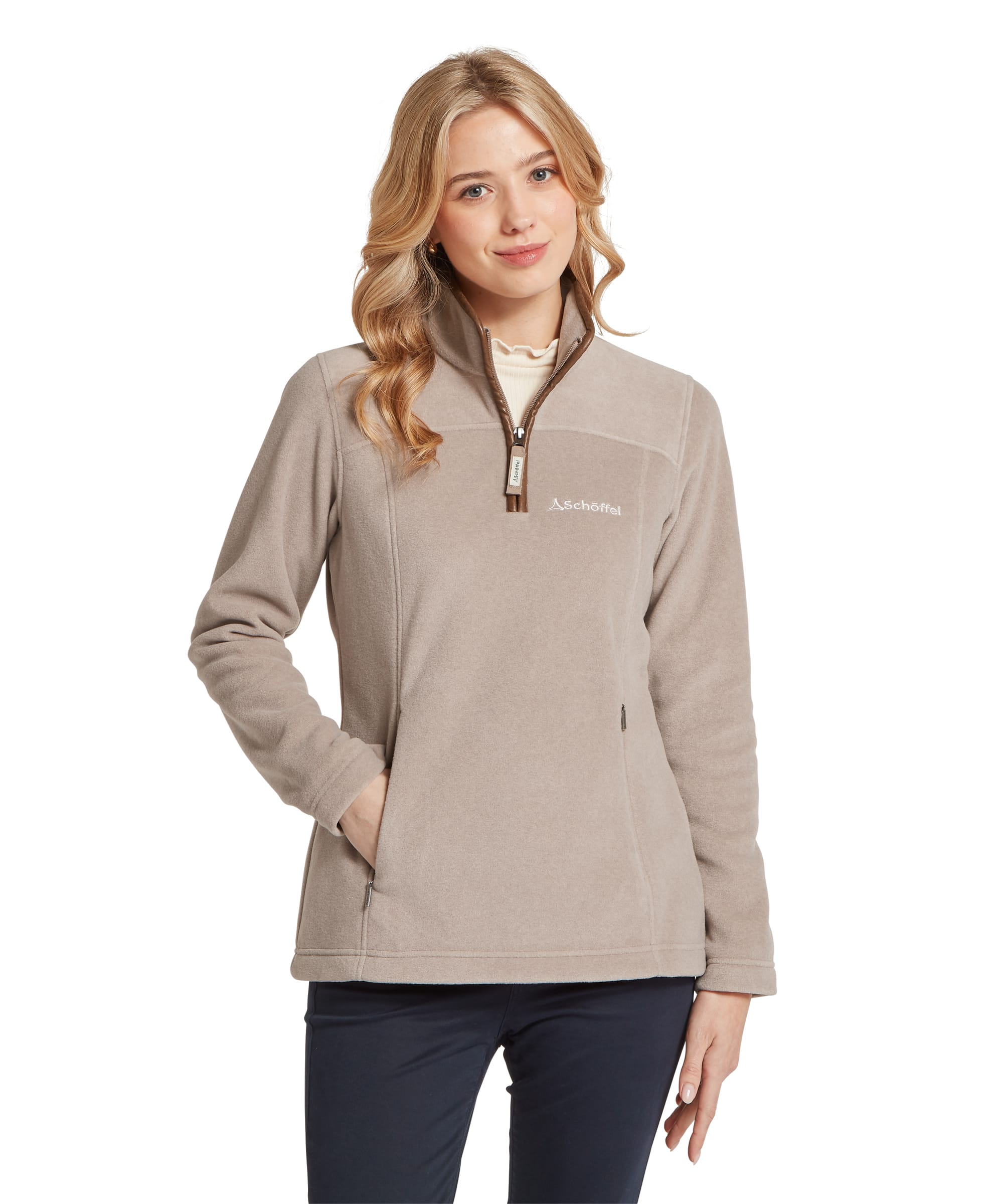 Women's Schöffel Tilton II Quarter-Zip Fleece in warm stone beige, with a fitted silhouette, contrast brown zip and trim, Schöffel chest logo, zip side pockets and stand collar, layered over a cream frill-neck top with navy trousers.