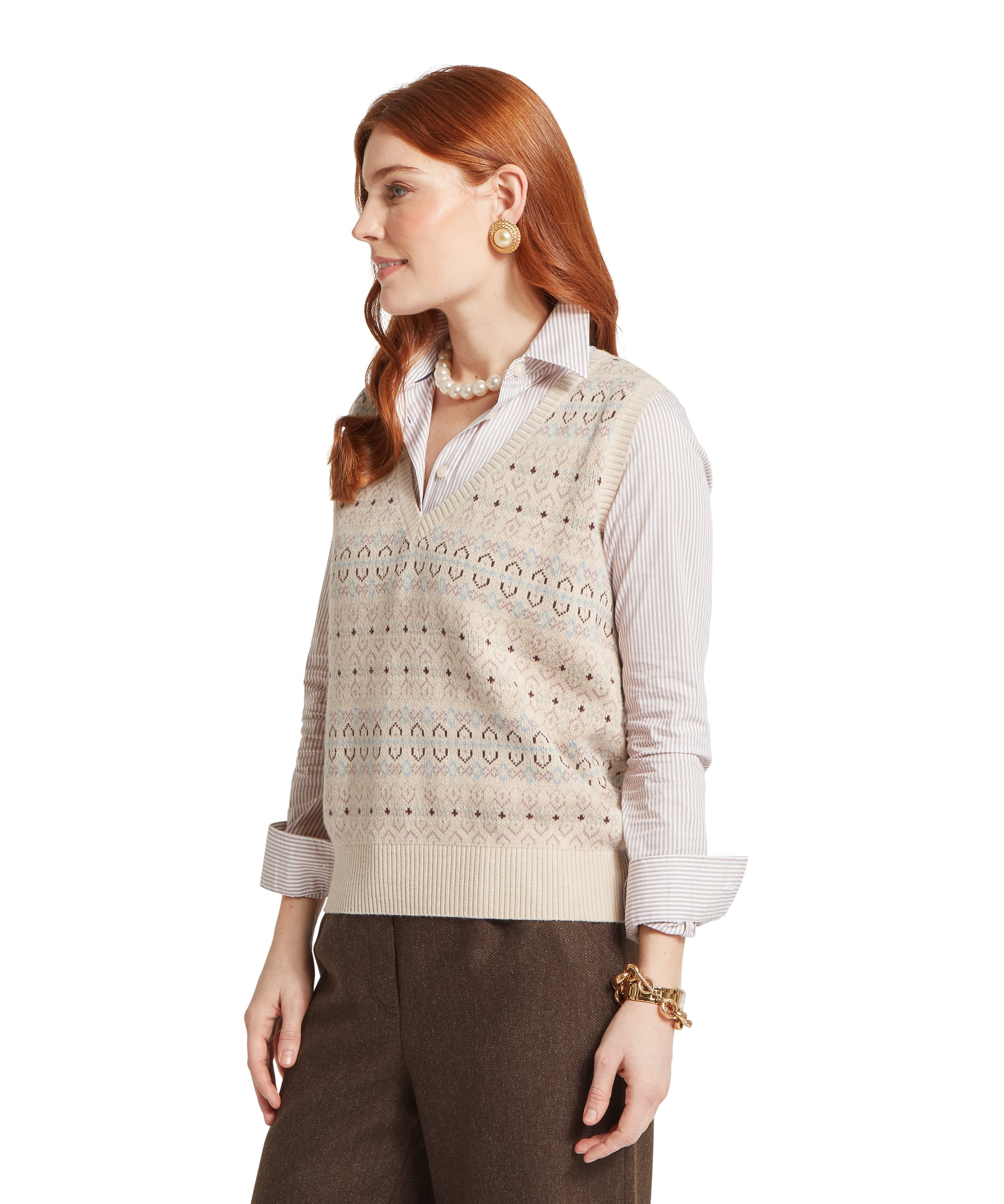 Schöffel Women's Tresness Fair Isle Vest in oatmeal cream with fairisle pattern throughout, side view with V-neck and ribbed hem, styled over a striped cotton shirt with brown wide-leg trousers and a statement pearl necklace